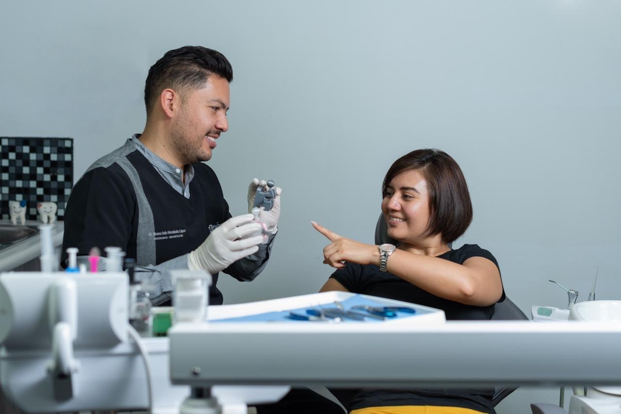 Two scientists in a lab examine a liquid sample together at a workstation with laboratory equipment and a light blue background