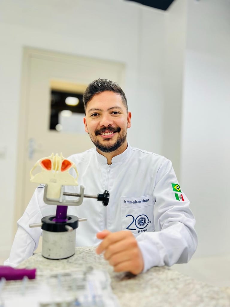 Male dentist in white coat smiling at camera with dental model showing teeth on laboratory counter